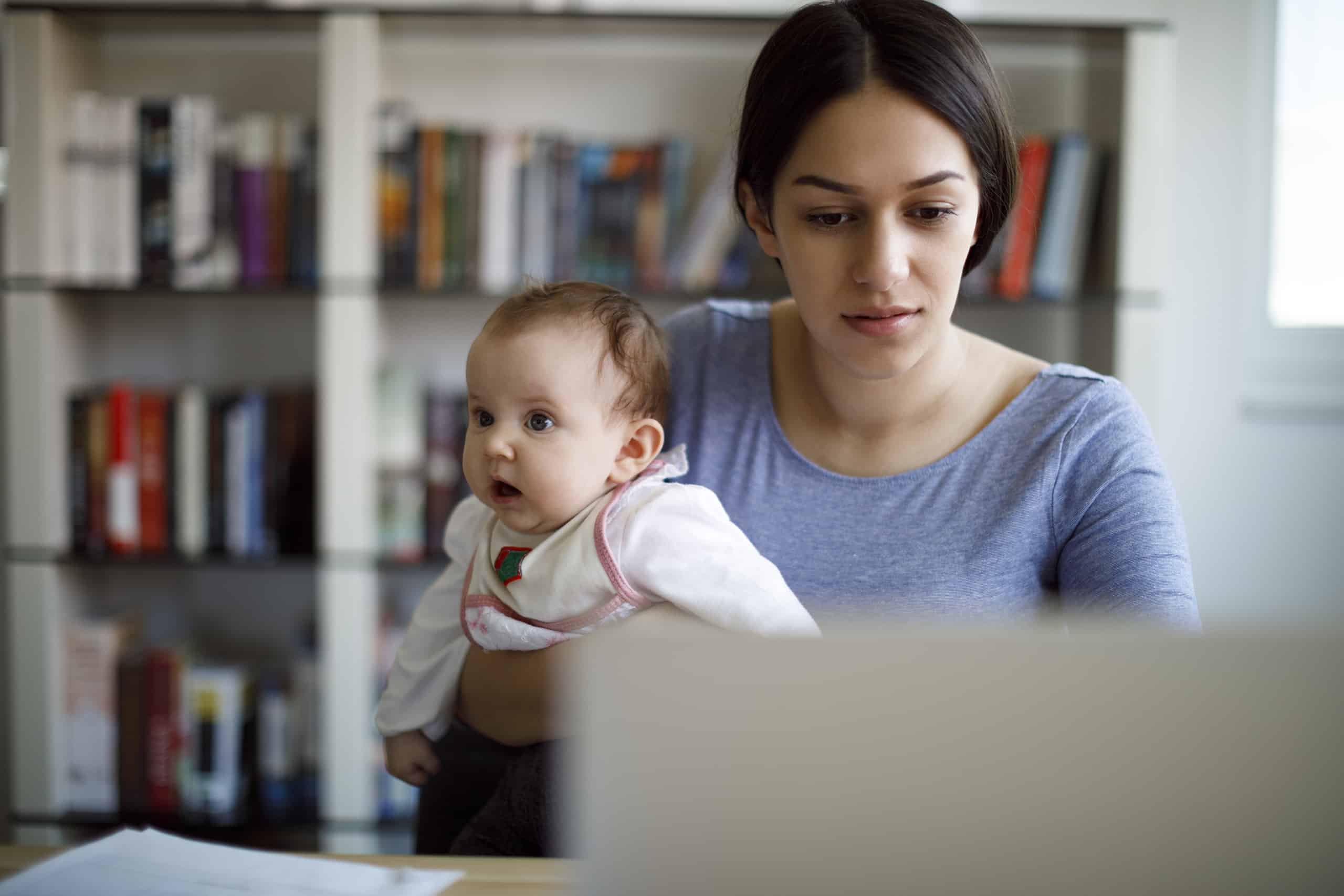 young mom with baby looking at computer